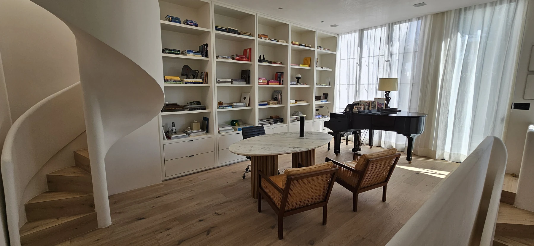 Biblioteca a medida con dos sillones claros en el proyecto Polanco