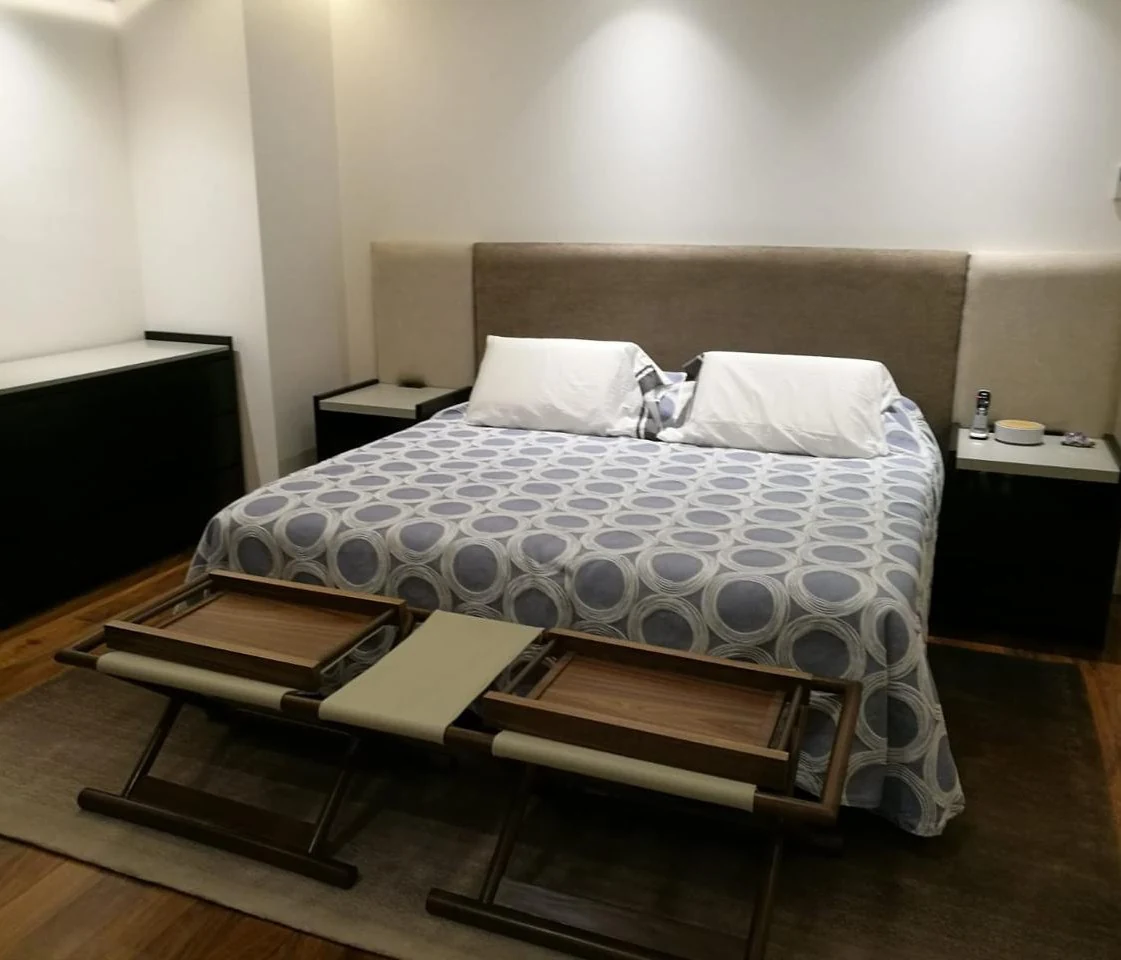 Recámara con cama y banca de piel del proyecto Monterrey